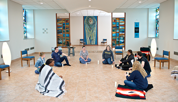 Men and women sit in a circle in a chapel