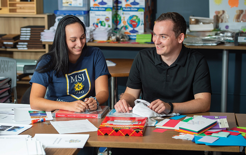 students at table smiling.