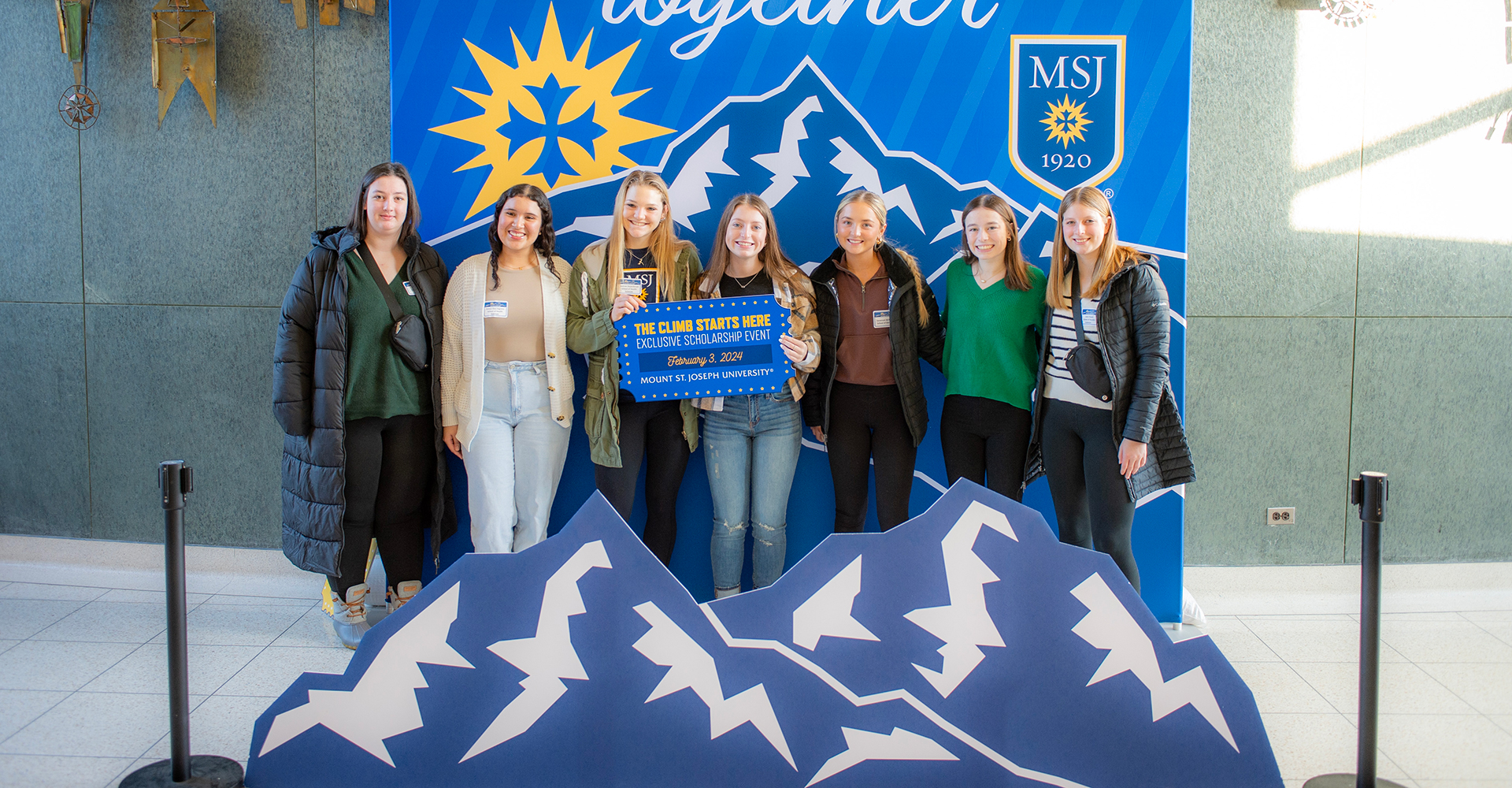 students holding sign at scholarship event