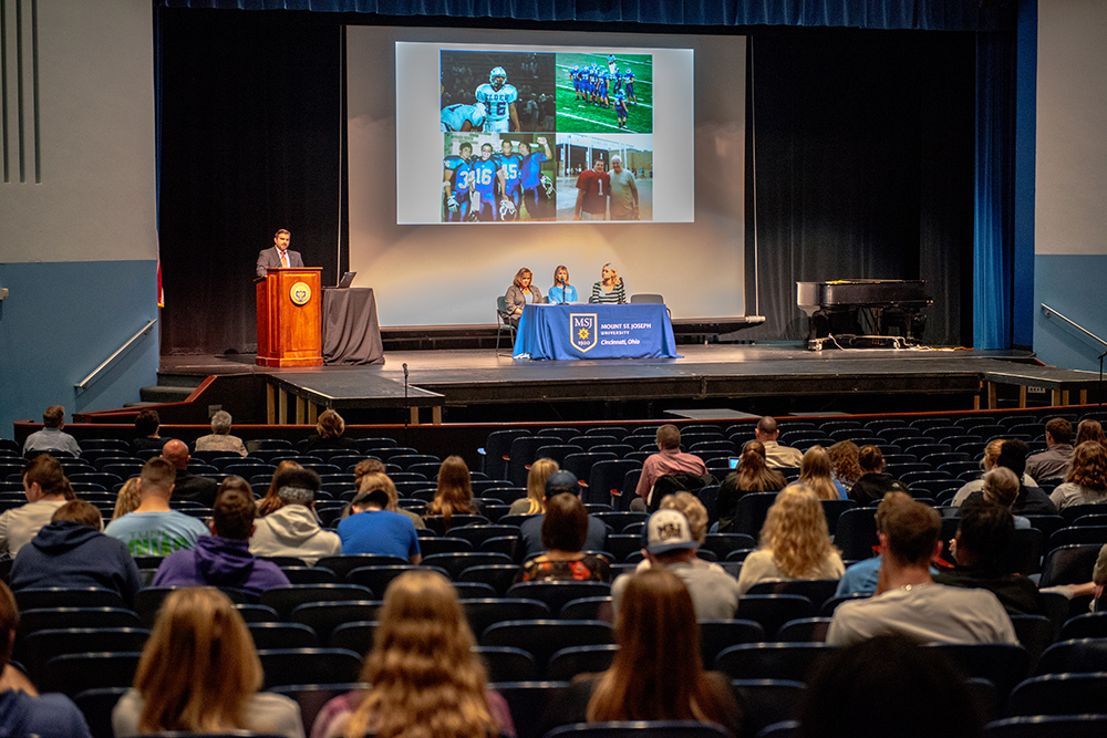 live speaker presenting slideshow in university theatre