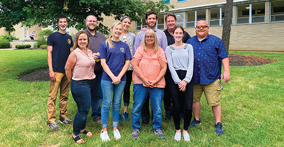  marketing team group standing in quad.