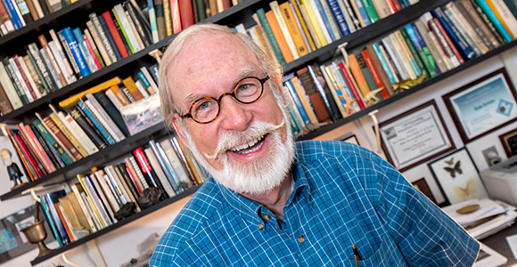 gene kritsky smiling in front of bookshelf.