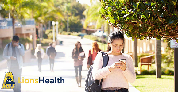 Mount St. Joseph University student walking with phone