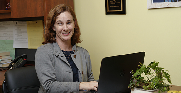 amy murdoch sitting at desk at mount st. joseph university