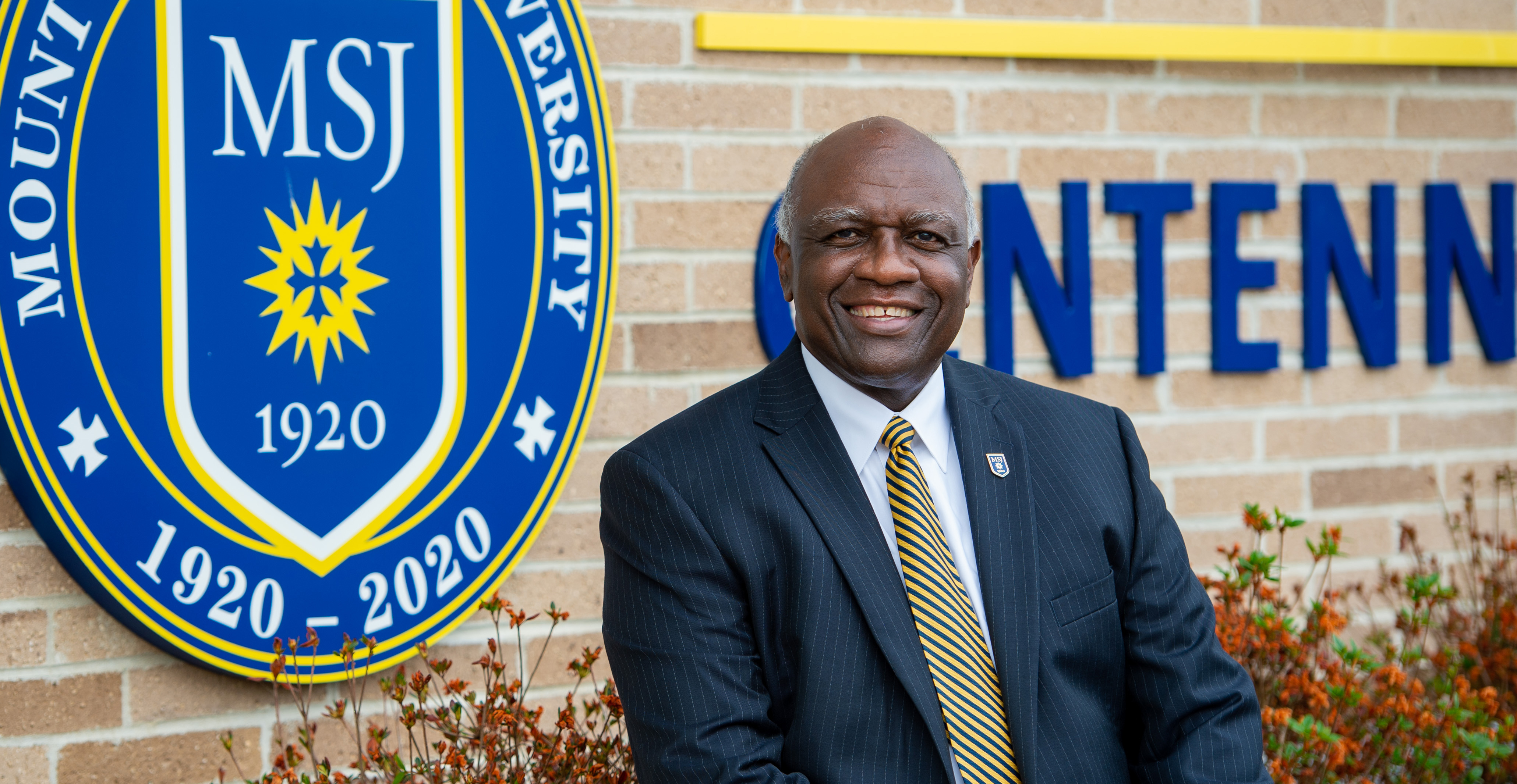 President H. James Williams in front of centennial field house.